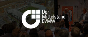 Ein großes weißes Logo und der Schriftzug „Der Mittelstand. BVMW“ überlagern ein Publikum, das zwei Rednern auf der Bühne zusieht, während im Hintergrund schemenhaft ein Stadion und ein Stadtgebiet zu erkennen sind.